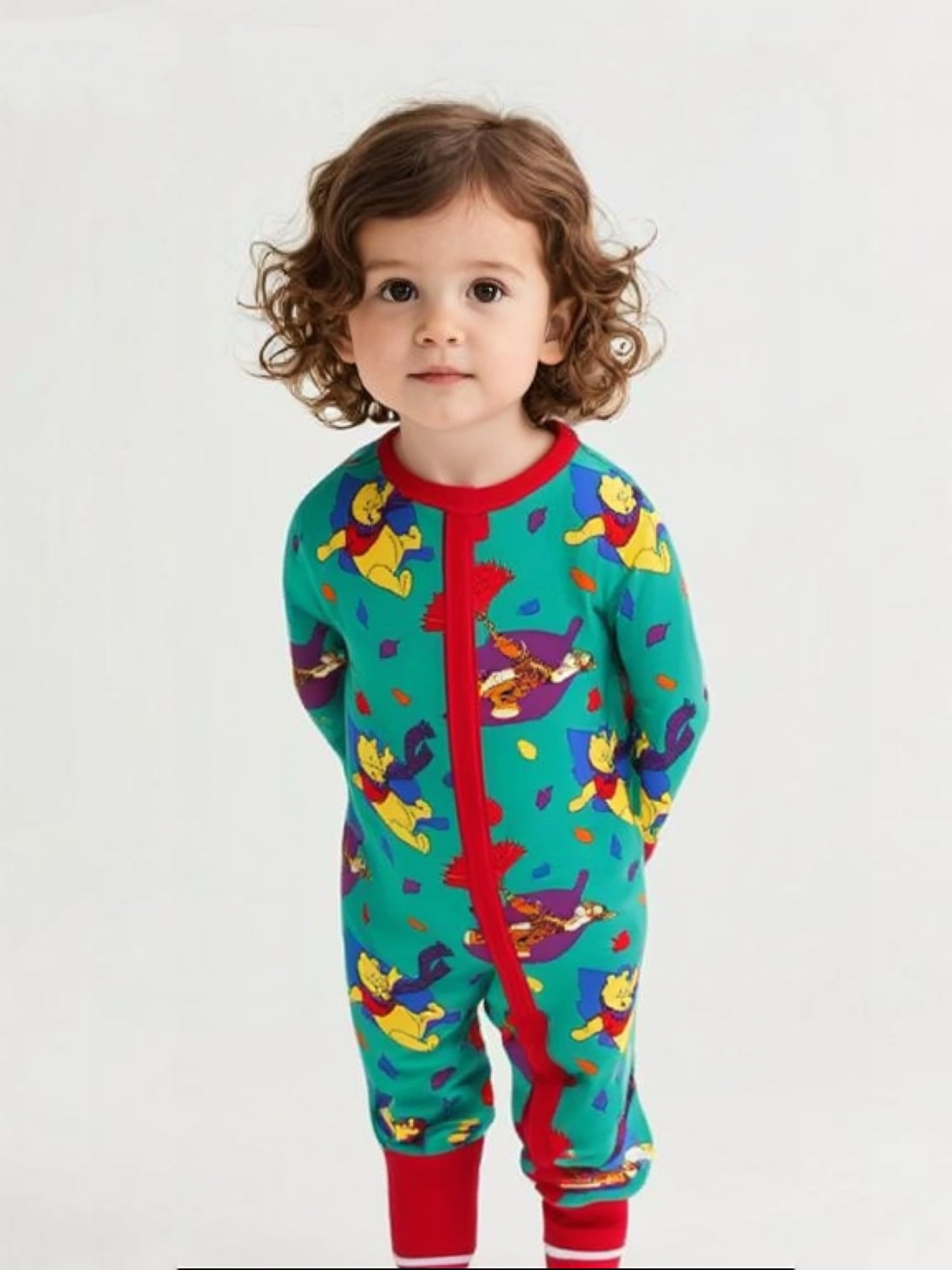 Child wearing a colorful onesie with cartoon characters on a white background