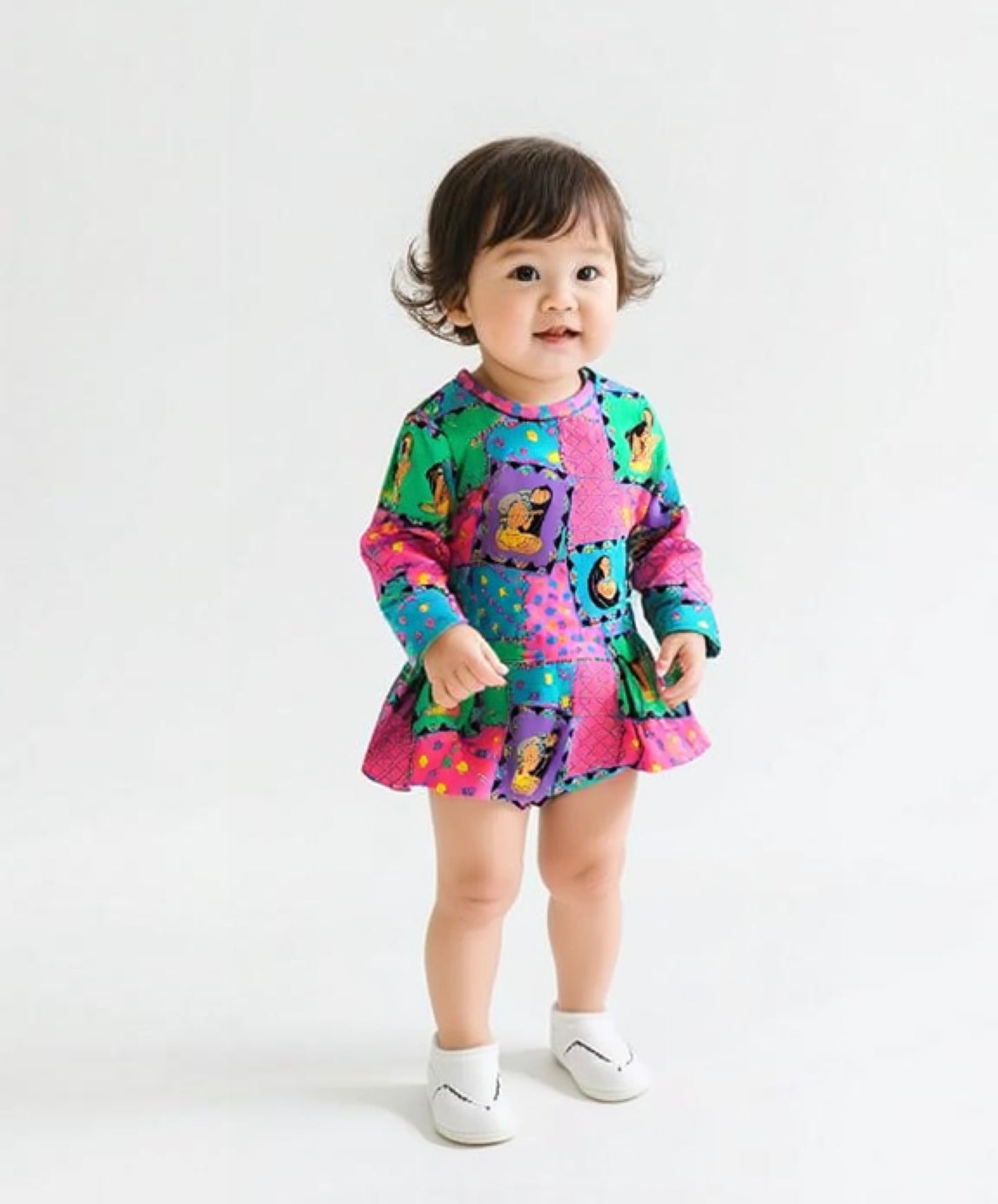 Child wearing a colorful patterned outfit on a white background