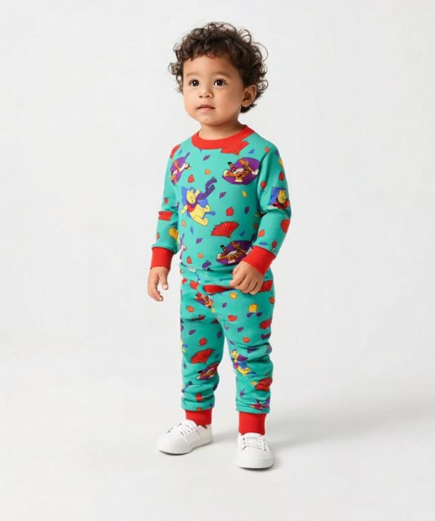Child wearing a colorful pajama set with cartoon characters on a white background