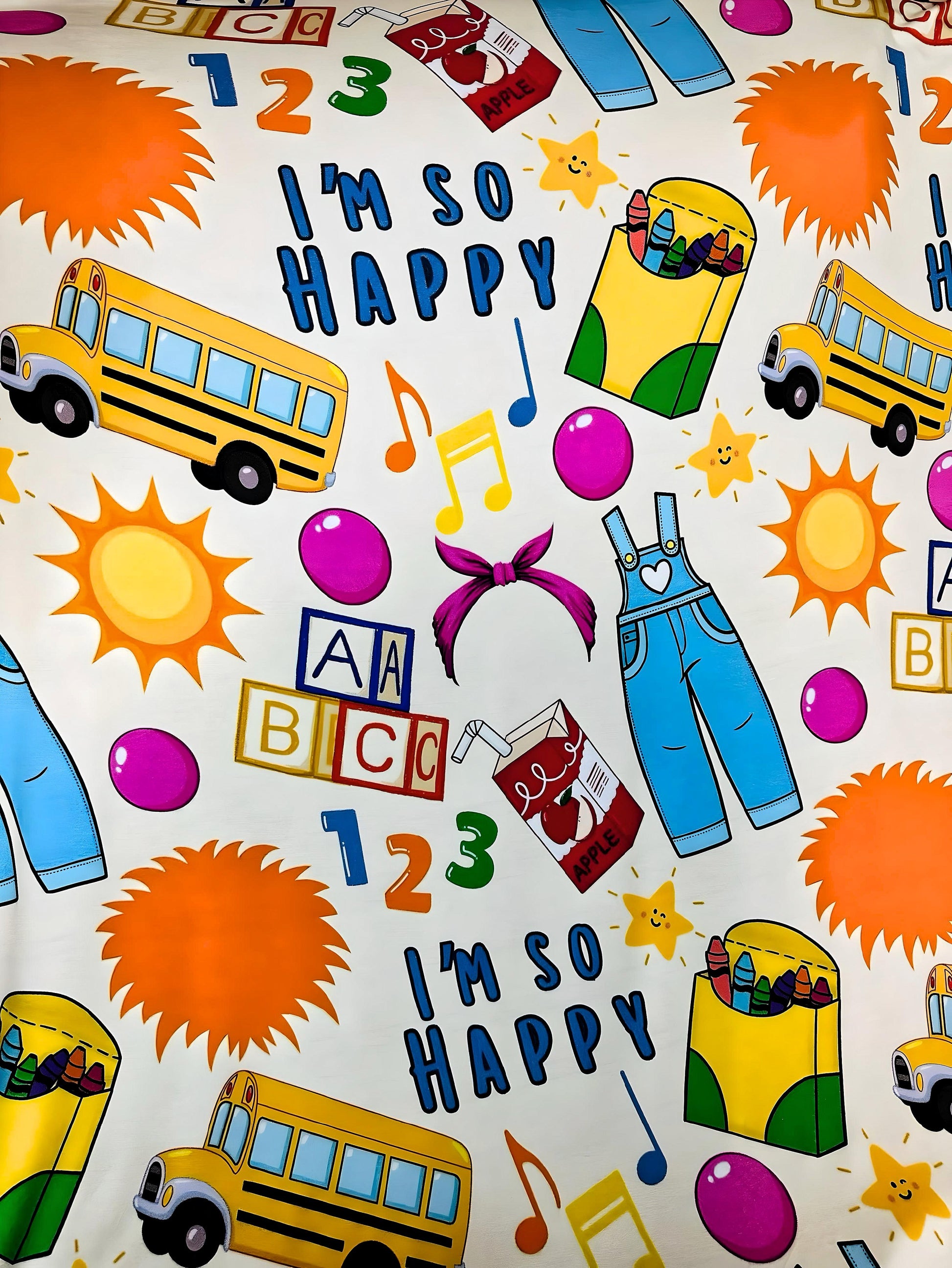Colorful toddler blanket with school bus, sun, crayons, numbers, letters, and "I'm so happy" text design on Learning is Fun Bamboo Blanket