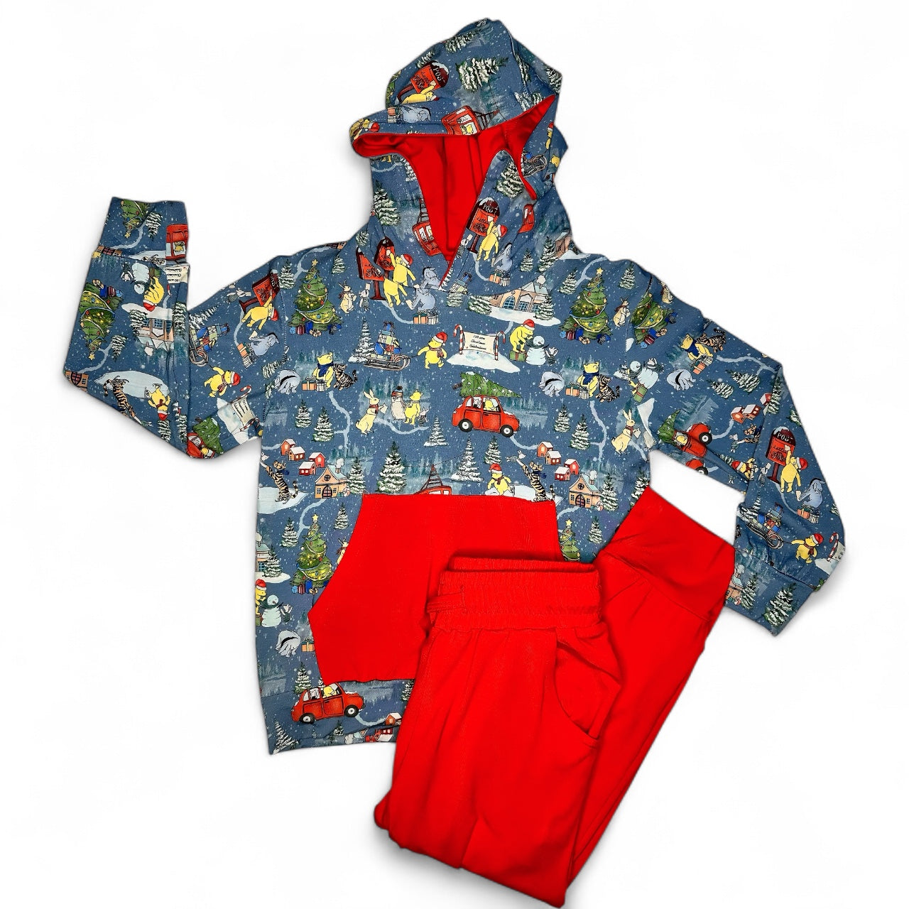 Children's raincoat with a colorful pattern and red interior, paired with matching red pants on a white background.
