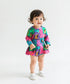 Child wearing a colorful patterned outfit on a white background