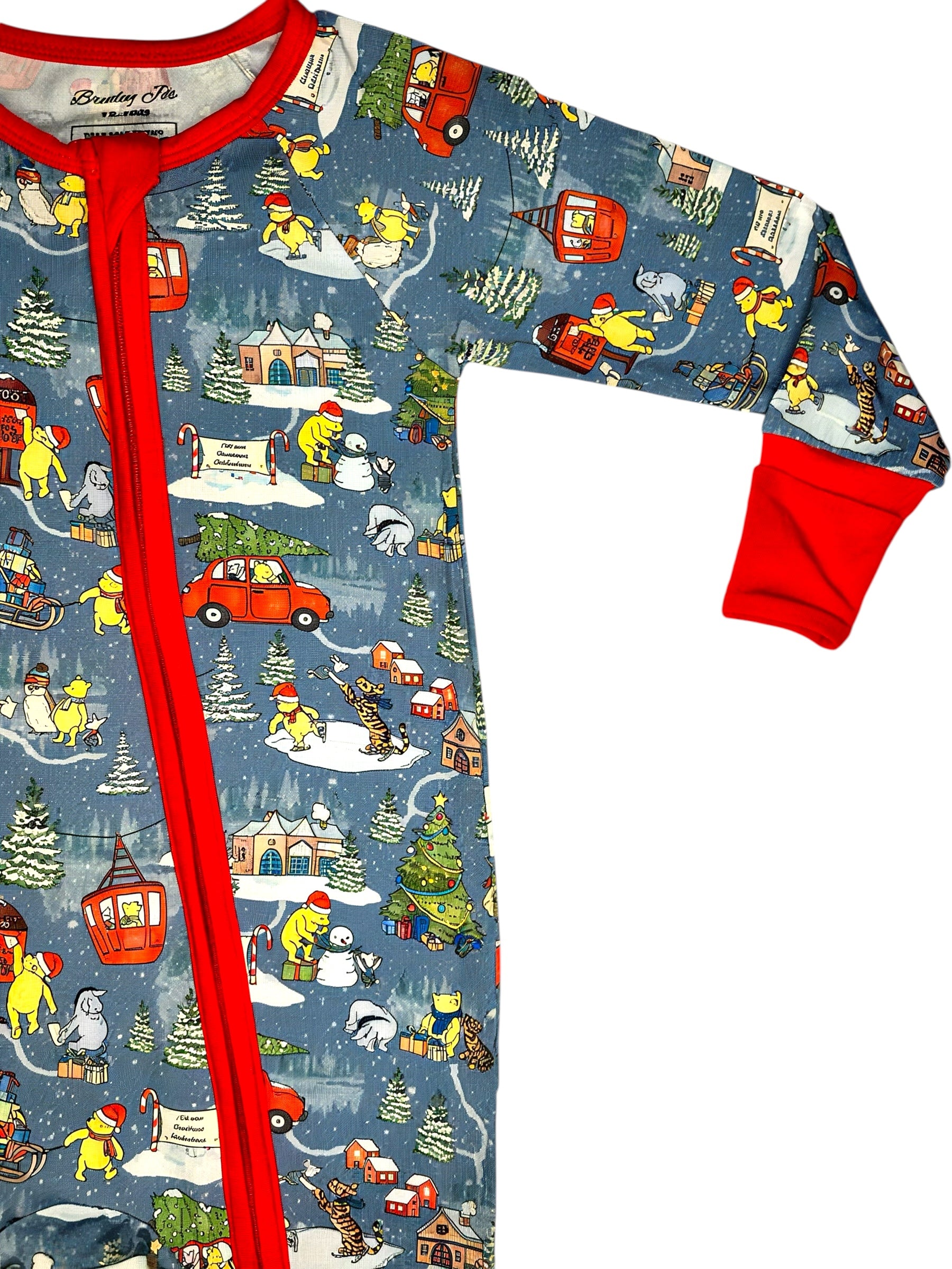 Children's pajama set with winter scene print and red trim on a white background