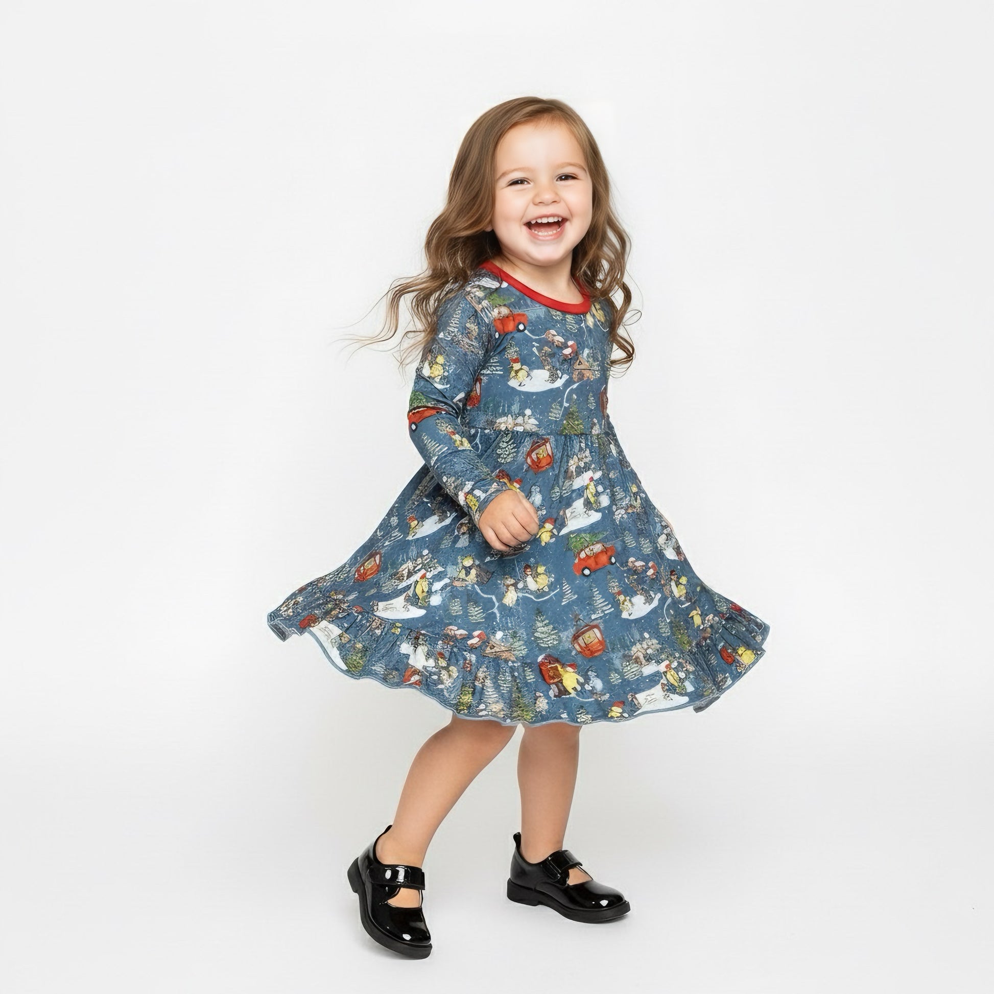 Child wearing a blue dress with a pattern of cars and animals on a white background