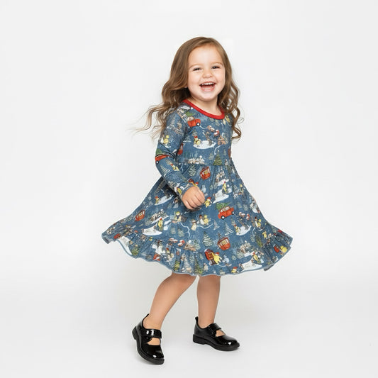 Child wearing a blue dress with a pattern of cars and animals on a white background