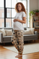 Woman wearing pajama pants with the manger pattern in a living room