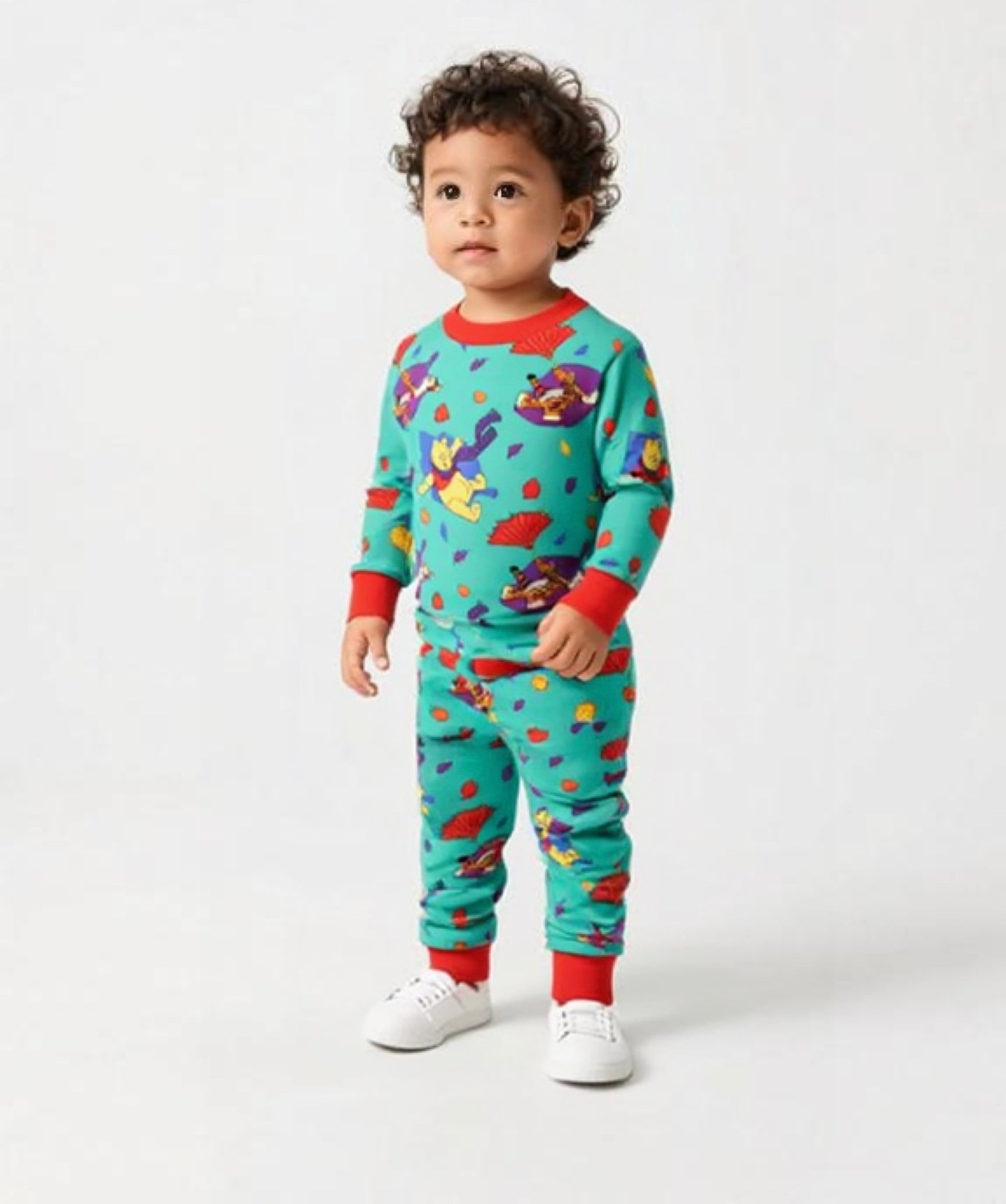 Child wearing a colorful pajama set with cartoon characters on a white background