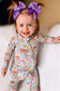 Toddler wearing Bunny Blooms Romper with playful bunny and floral print.